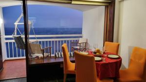 une salle à manger avec une table et un balcon dans l'établissement Sesimbra Sun&Sea - Beachfront Apartment!, à Sesimbra