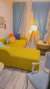 a living room with a yellow couch and a table at Apartament - Lisa in Budva