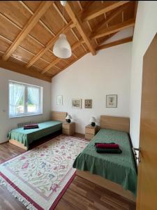 two beds in a room with wooden ceilings at Villa Stupar 