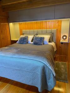 Hospedaria Cambará في كامبارا: سرير كبير في غرفة نوم بجدران خشبية