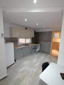 a kitchen with white appliances and a table in a room at maison d'hôte familiale للعائلات فقط in Sousse