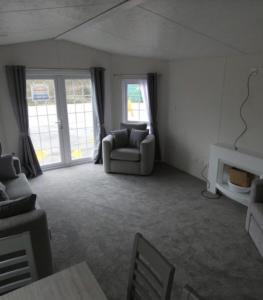 uma sala de estar com um sofá e uma cadeira em Langford Lodge em Great Billing