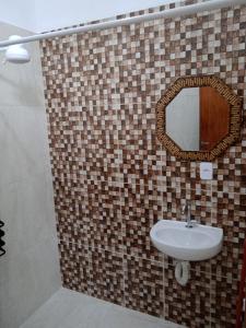 a bathroom with a sink and a mirror at Pousada Santana in Cachoeira Paulista