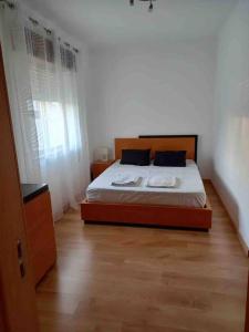 um quarto com uma cama e piso em madeira em apartamento Albufeira, Olhos de Água em Albufeira