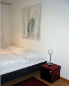 1 dormitorio con 1 cama y una foto en la pared en Nest - Poststrasse 24 en Zug