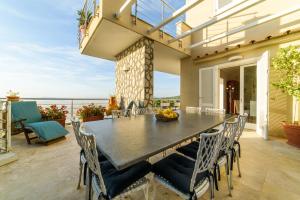 a table and chairs on a patio with a view of the ocean at Estate4home - Villa Maria Rosaria in Massa Lubrense