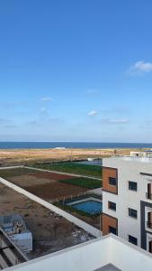 d'un balcon offrant une vue sur un bâtiment et l'océan. dans l'établissement Iquama Atawhid, à Nador