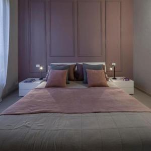 een groot bed in een kamer met 2 nachtkastjes en 2 bij Le Tre Ca', Ca' Cecilia, Ca' Nina, Ca' Vittoria in Asti