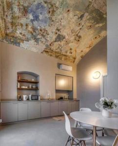 een keuken met een tafel en een plafond met een schilderij bij Le Tre Ca', Ca' Cecilia, Ca' Nina, Ca' Vittoria in Asti