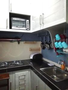 a kitchen with a sink and a microwave at Homestay Tawau in Tawau