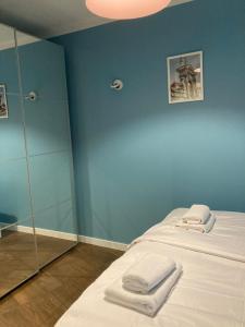 a blue room with a bed with towels on it at Apartament G76 in Kraków