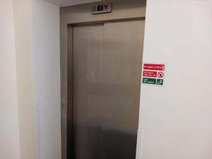 a elevator door in a building with a sign on it at Harbourside Apartment - 1 Bed Apartment in Whitehaven