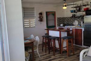 a kitchen with a counter and stools in a room at Casa LOLO on hills of Culebra in Culebra
