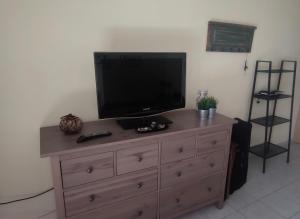 a wooden dresser with a television on top of it at Buena Vista in Aegenitissa