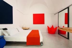 a bedroom with a red and white bed and red artwork at Casa Campari in Ostuni