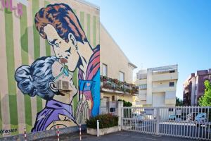 un mural de una mujer con una cámara en un lateral de un edificio en Agio Apartments Diamante - Bilocale, en Diamante