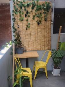 a table with two yellow chairs and a table with plants at Brand New 2 Bedroom Apartment in Seoul