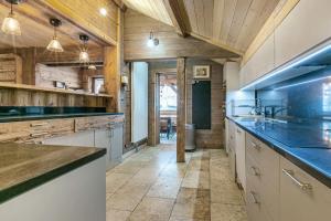 a large kitchen with wooden ceilings and wooden counters at Chalet NANOUK in Le Joseray