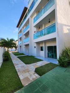 a large white building with a lawn in front of it at Mahalo Beach Residence in Porto De Galinhas