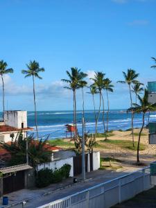 a view of a beach with palm trees and the ocean at Mahalo Beach Residence in Porto De Galinhas