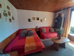 布里昂松Studio sympa avec terrasse , maxi 4 pers.Briançon的一间卧室配有一张色彩缤纷的床和一张沙发