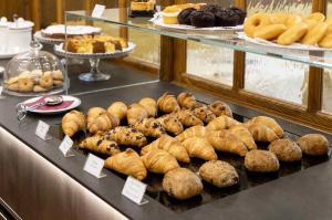 a display case with various pastries and breads and pastries at G. Hotel Des Alpes (Classic since 1912) in San Martino di Castrozza