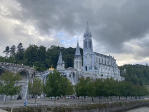 ein großes Gebäude mit einem Turm darüber in der Unterkunft Résidence du Soleil in Lourdes