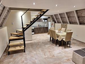 a dining room and kitchen with a staircase and a table and chairs at Cabañas Alpinas in Mendoza