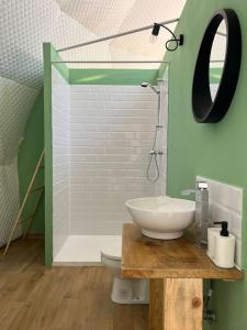 a bathroom with a sink and a toilet and a mirror at Starry Dome - Manta's Retreat Glamping Cornereva in Cornereva