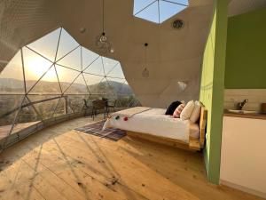 a bedroom with a bed in a room with glass windows at Starry Dome - Manta's Retreat Glamping Cornereva in Cornereva