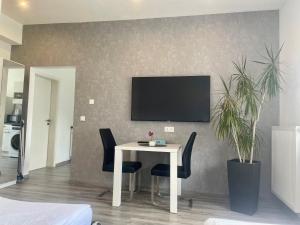 ein Esszimmer mit einem Tisch und einem TV an der Wand in der Unterkunft Apartment Lori in Mönchengladbach
