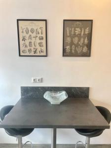 einem Tisch mit zwei Stühlen und zwei Bildern an der Wand in der Unterkunft Apartment Lori in Mönchengladbach