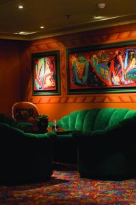 um quarto com um sofá verde e pinturas na parede em Storefjell Resort Hotel em Gol