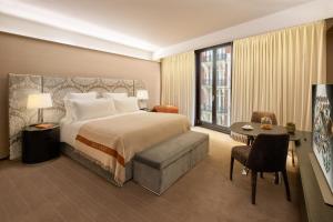 Cette chambre comprend un lit, un bureau et une table. dans l'établissement Bulgari Hotel London, à Londres