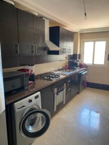 appartement en plein centre de casablanca في الدار البيضاء: مطبخ مع غسالة ملابس في منتصفها
