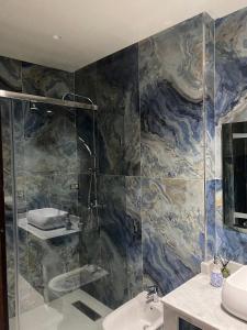 La salle de bains est pourvue d'une douche et d'un lavabo. dans l'établissement appartement en plein centre de casablanca, à Casablanca