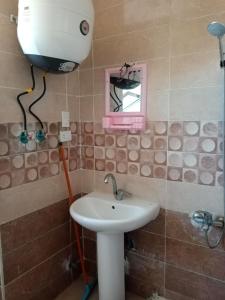 uma casa de banho com um lavatório e uma janela em استوديو عائلات فقط الساحل الشمالي ريتال فيو em Al Ḩammām