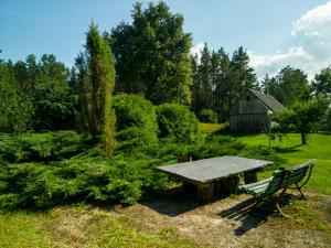 a bench and a table in a garden with a barn at Agroturystyka Leśna Dolina 