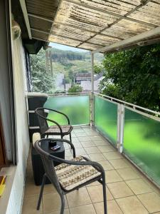 two chairs on a balcony with a view of a lake at Gemütliche Wohnung im Herzen vom Dorf in Mudersbach