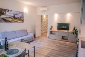 un soggiorno con divano e TV di BDC_7 Apartment a Parma