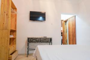 um quarto com uma cama e uma televisão na parede em Hotel pousada Krone Praia de Iracema Fortaleza em Fortaleza