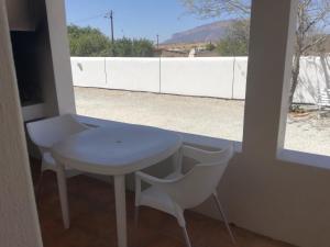 a white table and chairs in a room with a window at Aant Dorpseind in Vanrhynsdorp
