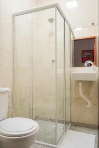 uma casa de banho com um chuveiro, um WC e um lavatório. em Hotel pousada Krone Praia de Iracema Fortaleza em Fortaleza