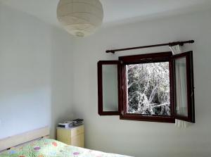 een slaapkamer met een raam, een bed en een spiegel bij Perivoli in Chorefto