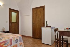 Un dormitorio con una cama y una mesa con una botella de vino en Comodissima casa per vacanza, en Parabita