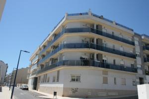 a large white building with balconies on a street at Duplex Las Marinas Orangecosta in Peniscola