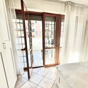 ボローニャにあるMaison Paradiso - Santa Viola Apartmentのベッドルーム1室(ベッド1台付)、ガラスのスライドドアが備わります。