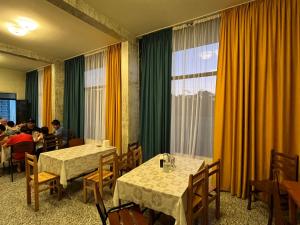 a restaurant with tables and people sitting at tables at TIANI Gest House in K'obulet'i