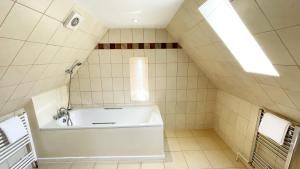 a bathroom with a bath tub in a attic at Catcune Family Suite in Gorebridge