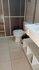 a bathroom with a white toilet and a sink at Apartamento 3 minutos da orla in Capão da Canoa